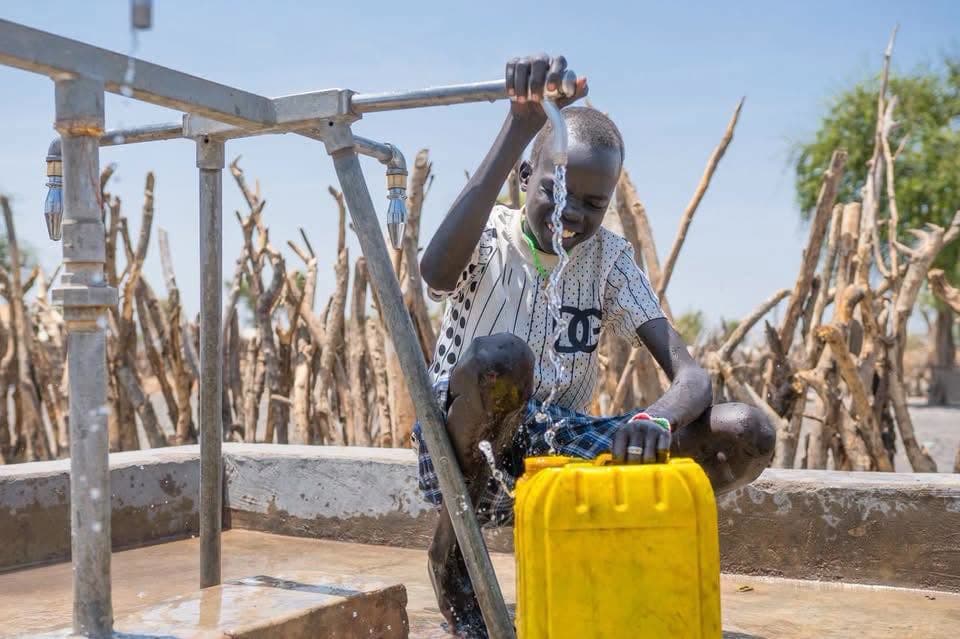 A boy drinking from a new water pump